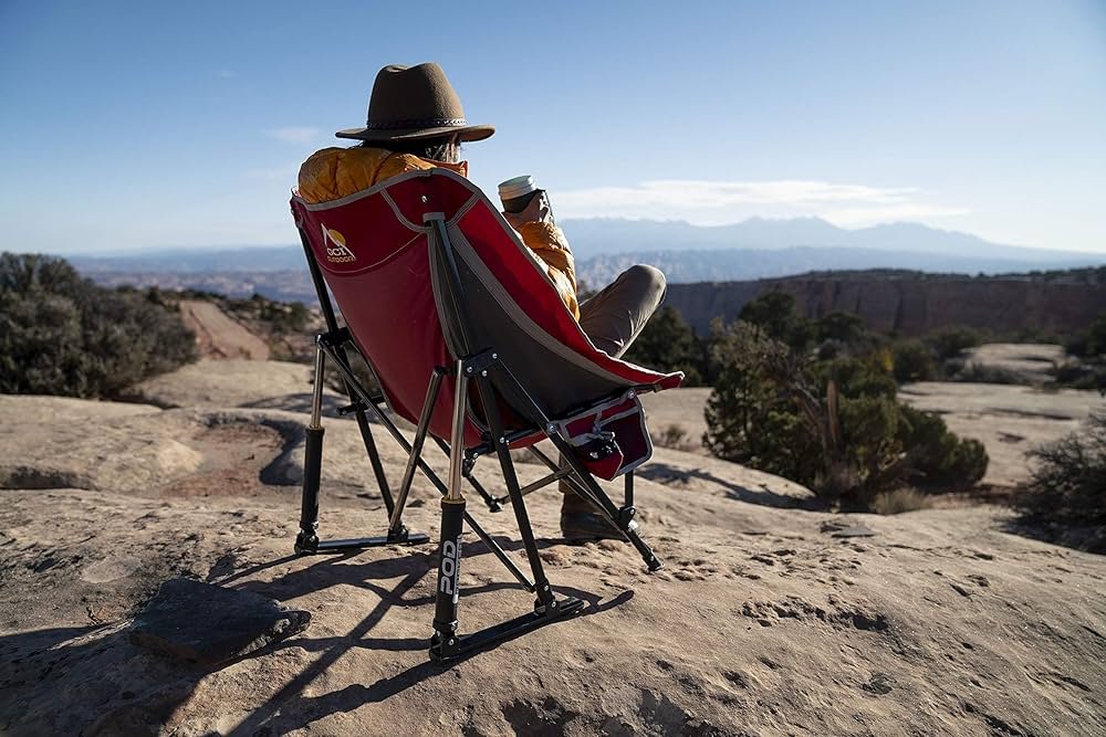 A person is relaxing in the GCI Outdoor MaxRelax Pod Rocker.